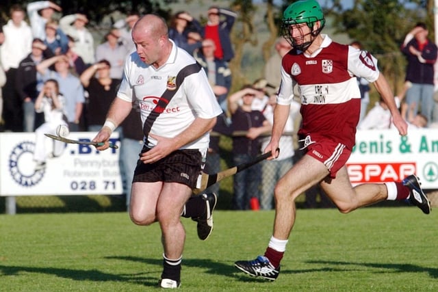 Dungiven's Geoffrey McGonigle makes a solo run at goal pursued by Ballinscreen's Paul Kelly in the 2003 County hurling final. (0209C23)