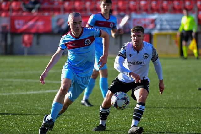 Institute’s Oisin Devlin gets to the ball ahead of Bangor’s Jack Henderson.  Photo: George Sweeney