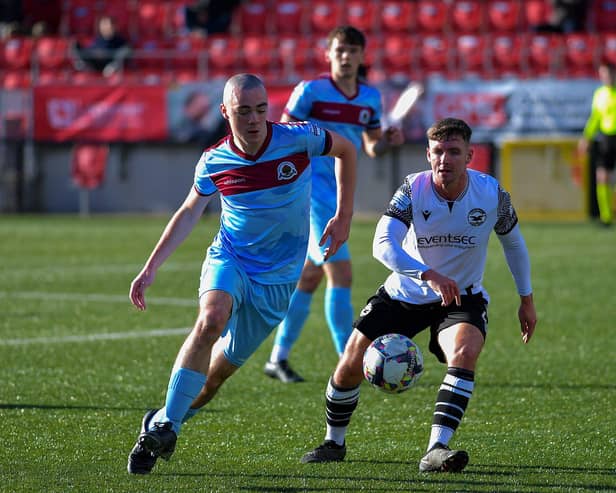 Institute’s Oisin Devlin gets to the ball ahead of Bangor’s Jack Henderson.  Photo: George Sweeney