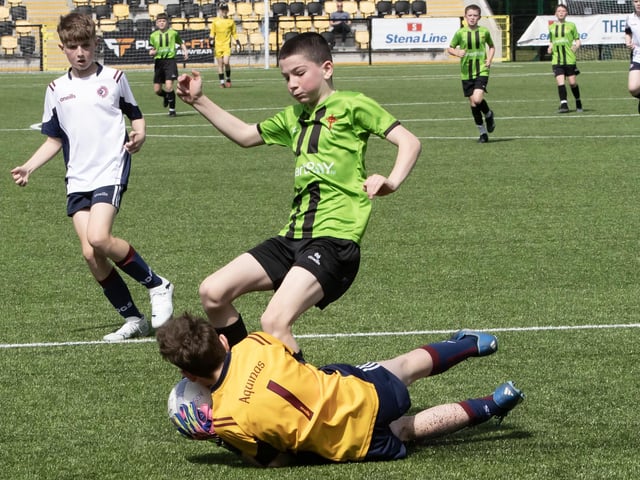 The Aquinas Grammar goalkeeper saves bravely at the feet of St. Joseph's striker Gallagher.