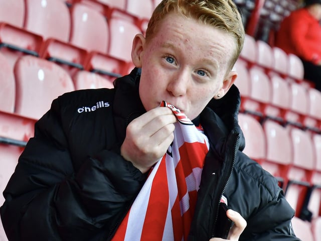 This young Derry City fans kisses the badge at Celtic Park.
