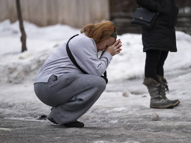 MINNEAPOLIS, MINNESOTA - JANUARY 08: Katie Brown holds her hands to her face at a memorial for Renee Nicole Good near the site of her shooting on January 08, 2026 in Minneapolis, Minnesota. (Photo by Stephen Maturen/Getty Images)