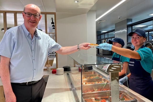 A Crossroads restaurant staff member serves up lunch to Western Trust Chief Executive Neil Guckian.
