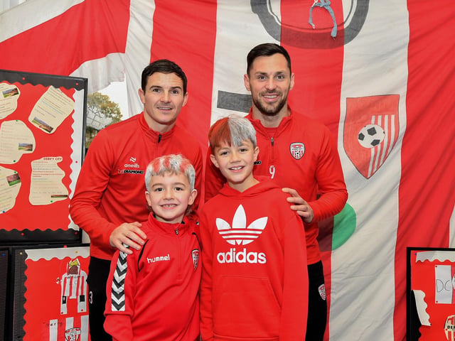 Faolán and Lorcán,from Gaelscoil Eadain Mhoir, pictured with Derry City’s Ciaran Coll and Pat Hoban during their visit to the school on Monday morning. Photo: George Sweeney