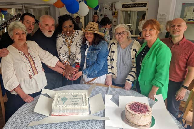 Colr Lilian Seenoi Barr, Mayor of Derry City & Strabane, cuts the cake with Dunvale House tenants. Also pictured, Dunvale House Manager Kelvin Hegarty (far right) and Apex Director of Supported Living, Deirdre Walker (second from right).
