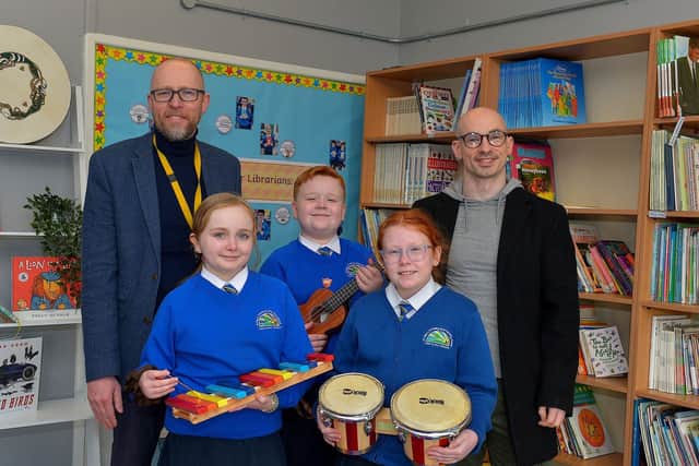 Principal Gareth Blackery, and Eamonn McCarron, from Project Sparks, pictured with P7 pupils Aoibhe, Cillian and Eabha with some of the musical instruments donated to St Paul’s Primary School, Slievemore on Tuesday last. Photo: George Sweeney. DER2310GS – 010