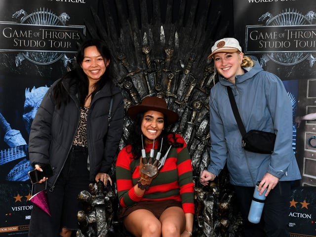 Rachel, Dadha and Hannah from the United States, visiting Derry for Halloween, pictured with the throne, from The Games of Thrones, in Guildhall Square on Monday afternoon. Photo: George Sweeney