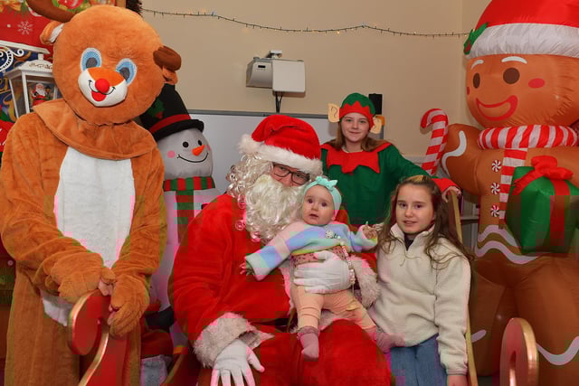 Ellie and Kelsey pictured with Santa and his helpers at the Galliagh Community Christmas Craft Fair and Wonderland on Saturday afternoon. Photo: George Sweeney