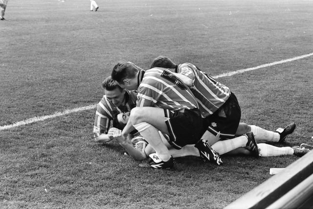 'Pizza' is mobbed after scoring the opening goal.