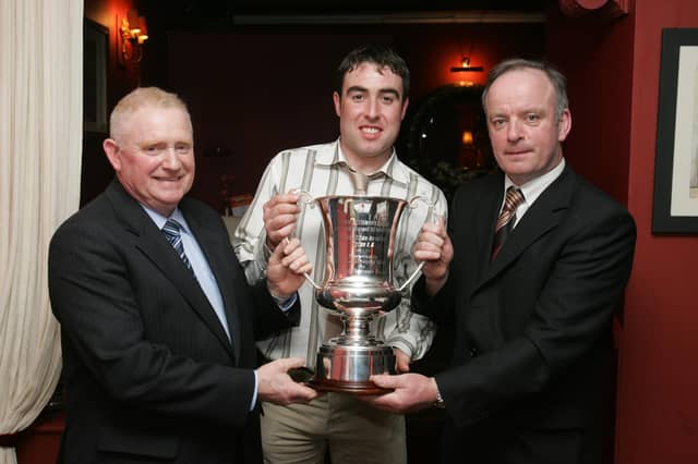Mick Murphy, County Games Coaching manager, right, presenting the Sandy Harper Cup for winning the Donegal Division 1 'B' League to Patrick McLaughlin, chairman, and Patrick Kelly, captain, Malin GAC. (2102C47) : Malin GAA Dinner