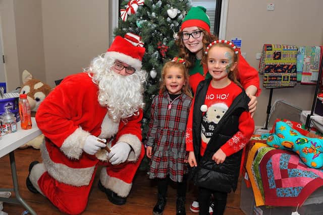Posing for a picture with Santa at the Galliagh Community Response Christmas Craft Fair held in Pio House Parish Centre in 2022, in aid of Foyle Down Syndrome Trust.  Photo: George Sweeney. DER2250GS – 88