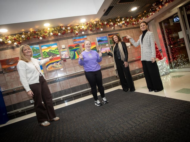 Artist Tori shows off some of her artwork at the entrance to the Lisnagelvin Shopping Centre on Wednesday to mum Dara, Aisling Doherty, Centre Manager and Louise Moorhead, Arts Development Officer, Gasyard Centre, Derry. (Photos: Jim McCafferty Photography)