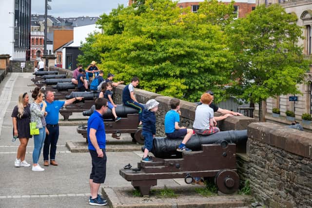 Tourists enjoying the cannons on the Derry Walls.