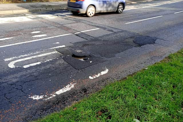 A large rain water-filled pothole on Northland Road.