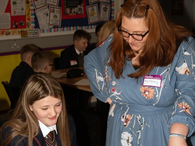 Miss Halpenny helping one of the new Year 8 students with her timetable on Monday at Oakgrove College. : Oakgrove Integrated College welcomes latest influx of Year 8 pupils