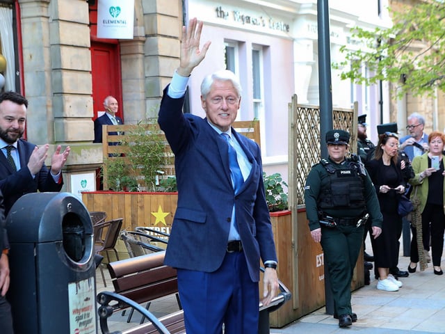 Bill Clinton waves to the public in Guildhall Street