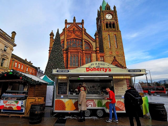 People getting hot food at Christmas Market in Guildhall Square on Friday afternoon. Photo: George Sweeney. DER2250GS – 58