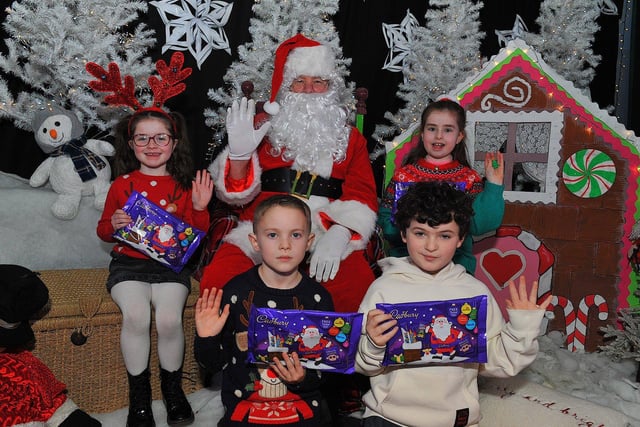 St Eithne’s Primary School P4 pupils Kadie, Ryan, Parker and Macey from Mrs Coyle’s class pictured with Santa during his visit on Friday. Photo: George Sweeney. DER2250GS – 53