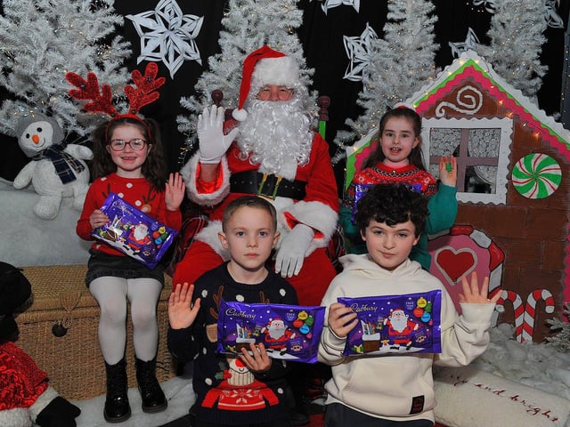 St Eithne’s Primary School P4 pupils Kadie, Ryan, Parker and Macey from Mrs Coyle’s class pictured with Santa during his visit on Friday. Photo: George Sweeney. DER2250GS – 53