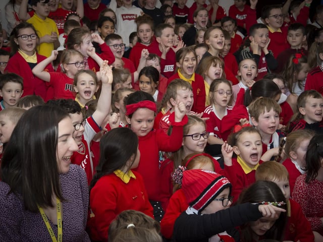 Pupils and staff of Steelstown Primary School cheer the arrival of Derry City trio Shane and Patrick McEleney and Michael Duffy on Tuesday.