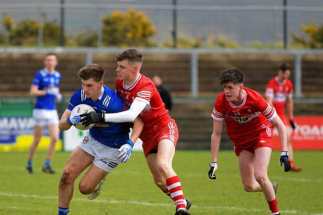 Derry pair Rían Collins and Ríaíri Biggs tackle Cavan’s Oisin Maguire. Photo: George Sweeney