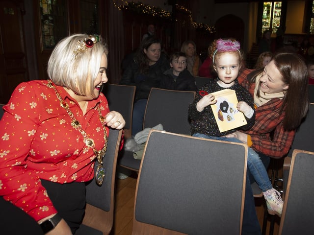 This young lady shows the Mayor her Christmas card made at Saturday's arts and crafts.:.