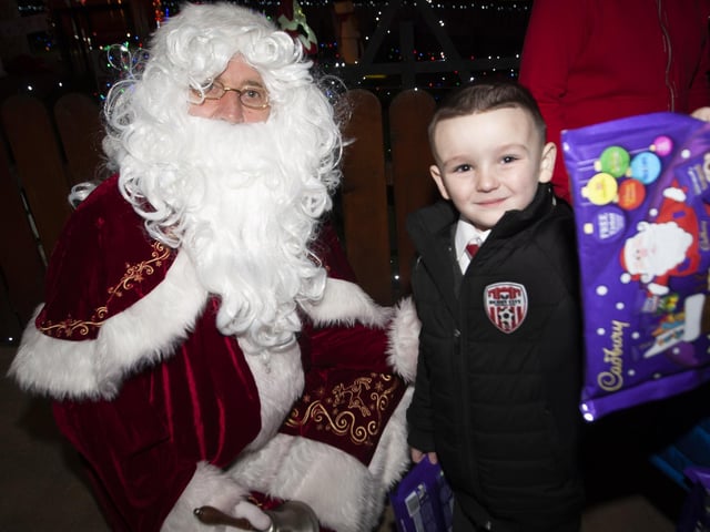 Master Noah Cavanagh shows off his selection box to Santa Claus.