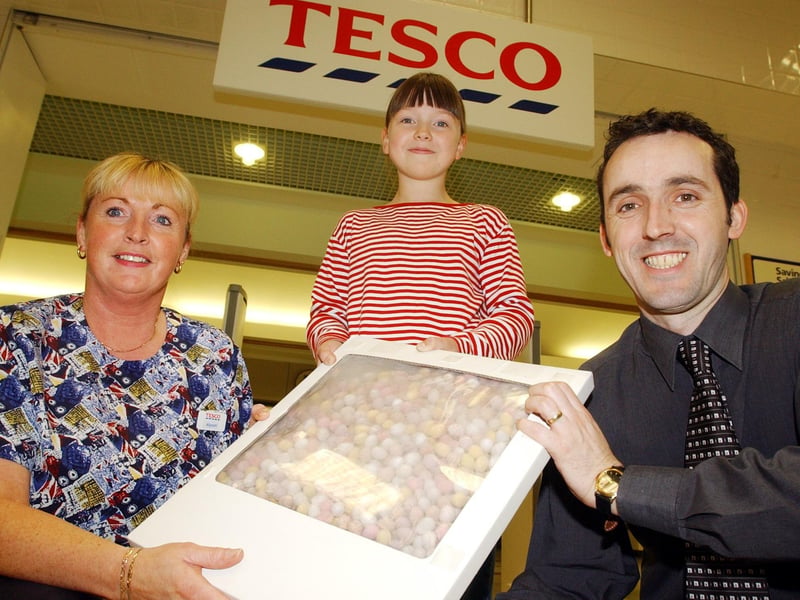 Allyson Simpson, customer services, and John Wade, fresh food trading manager, Tesco, presenting Kristina Bradley, Rushcroft Gardens, with OSL mini eggs after she won the Easter Egg Treasure Hunt. (1605A35)