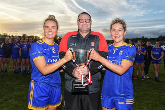Joint Steelstown captain Caira McGurk (left) and Aoife McGough receive the Derry Senior Championship trophy from Derry LGFA Chairman Sean Hamill