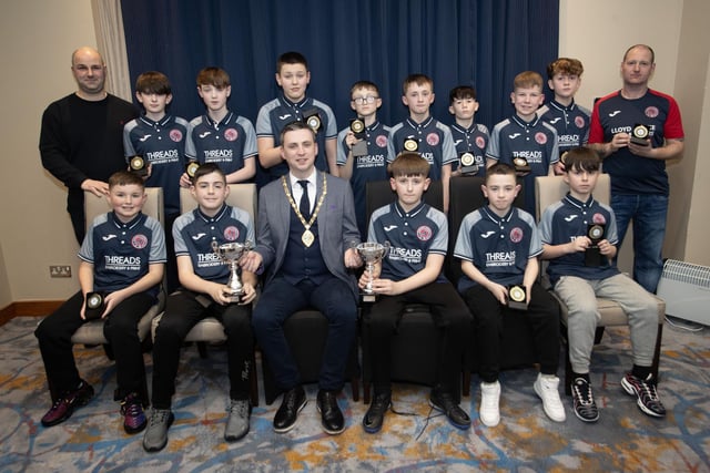 The Deputy Mayor, Jason Barr presenting Clooney FC 2011s with the Champions League trophy and Winter Cup at the D&D Youth Awards at the City Hotel on Friday night last. Included are coaches Gavin Bond and Ronnie McGee.