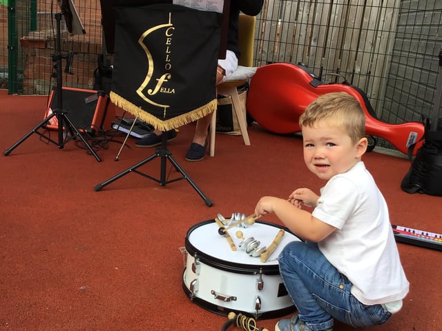 A young drummer playing along with the Cello Fella
