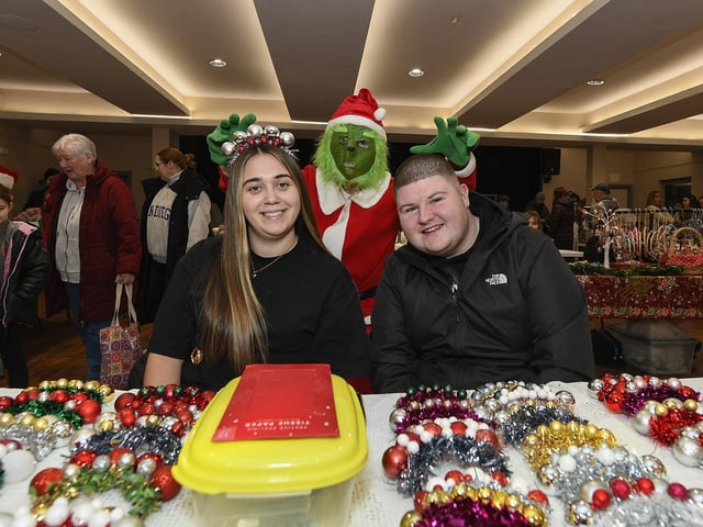 The Grinch creeps up on stall holders Chloe and Dylan during the Galliagh Christmas Craft Fair held in Pio House. Photo: George Sweeney