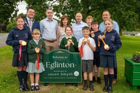 A new sign marking Eglinton Village as the birth place of six times Paralympic Champion Jason Smyth has been put in place in the village’s Main Street close to the Carmoney Road junction to commemorate his achievements.  Derry City and Strabane District Council Mayor,  Councillor Ruairí McHugh pictured with Jason Smyth following  the  official unveiling of a new sign recognising  Eglinton Village as the birth place of six times Paralympic Champion as, Anna, Ellie, Lucy, Logan, Oisin and Erin from Broadbridge and Eglinton Primary schools each held one of the athletes Gold Medals. Included are  Jason's parents Diane and Lloyd, Pam Hardeman from the community and local Councillor Declan Norris.  Picture Martin McKeown. 23.06.25