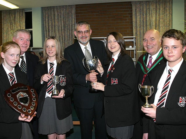 Rev. Bert Tosh, guest speaker at Clondermot High School's annual Prize-Giving, presents trophies to (from left) Julie Long, with the Shield for Care and Consideration, Nicola Long, cup for Academic Achievement (KS3), Charlene Curry, cup for Academic Achievement in Year 11 and Denver Lewis, Academic Achievement in Year 8. Included are Bertie Faulkner, chairman of the Schools Board of Governors and John Magowan, Headmaster. (2810T06).:Derry and Donegal secondary school pupils in October 2003
