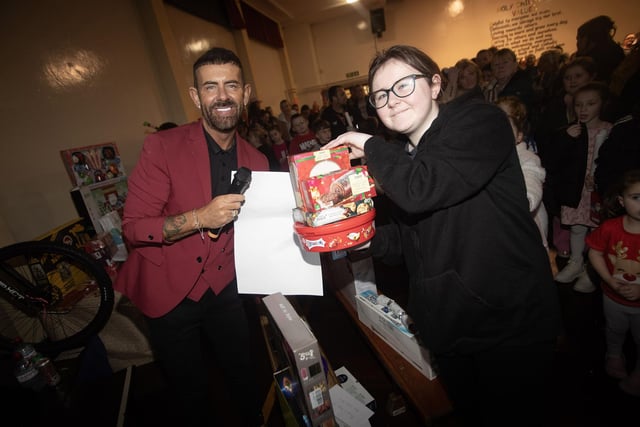 MC Micky Doherty hands out one of the first prizes at Thursday night's rickety wheel.