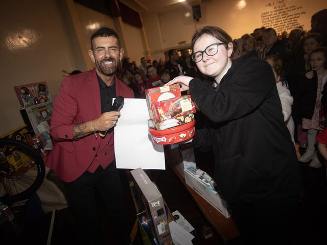 MC Micky Doherty hands out one of the first prizes at Thursday night's rickety wheel.