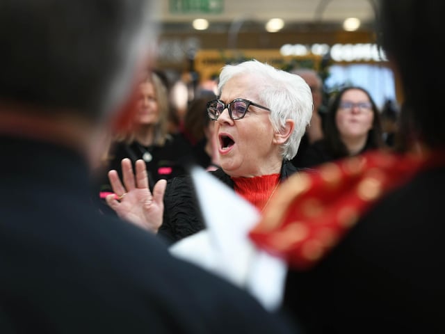 Choir members singing at Foyleside Shopping Centre.