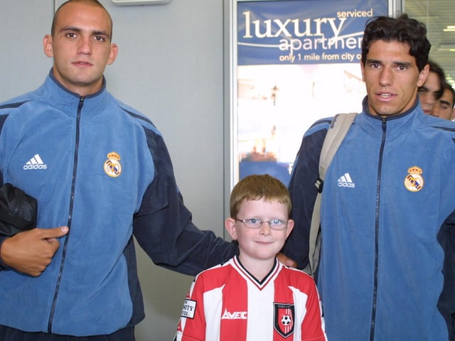 Young Derry City supporter Christohper McGirr with two of the Real Madrid players when they arrived at the City of Derry airport.(2208JB33)