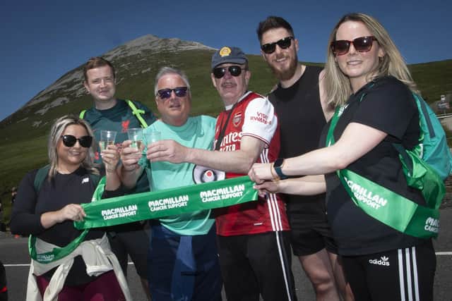 The Housing Executive’s Eddie Doherty and event organiser Noel McNulty pictured with some of the finishers at the bottom of Mount Errigal on Thursday.