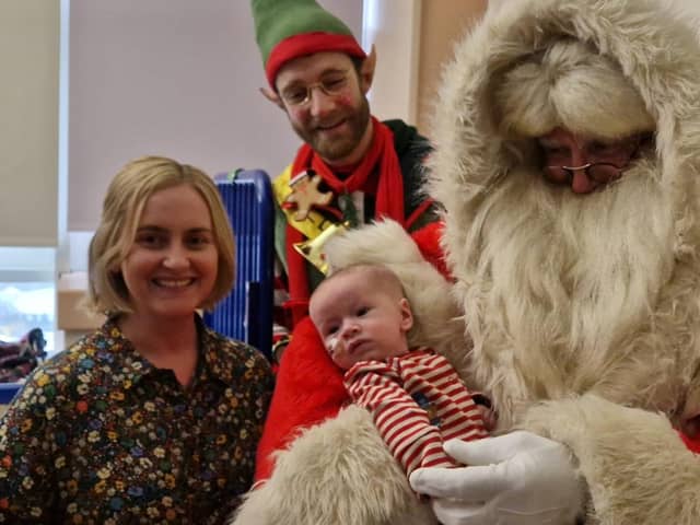Little Jamie Harkin (four months) and his mother Rachel from the Hatmore area with Santa and one of his elves at Altnagelvin Hospital in Derry on Thursday.