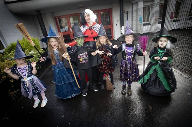 Cruella D'Evil, (aka Ms Sutherland) pictured with some of the younger witches at Hollybush PS on Wednesday morning. (Photos: Jim McCafferty Photography) : .