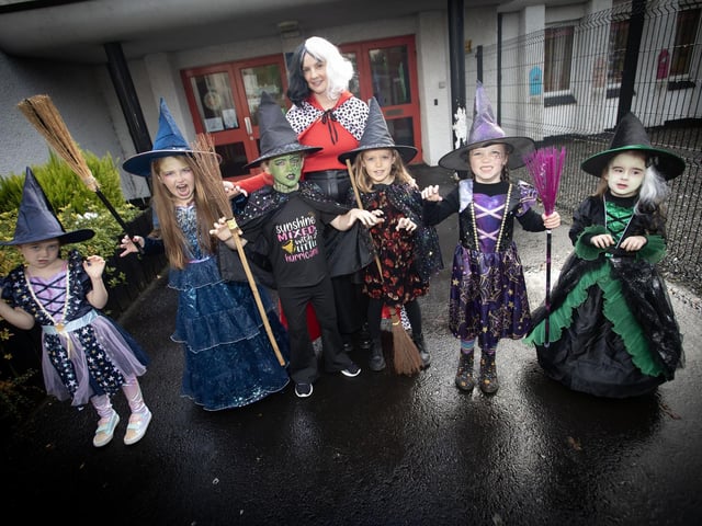 Cruella D'Evil, (aka Ms Sutherland) pictured with some of the younger witches at Hollybush PS on Wednesday morning. (Photos: Jim McCafferty Photography) : .