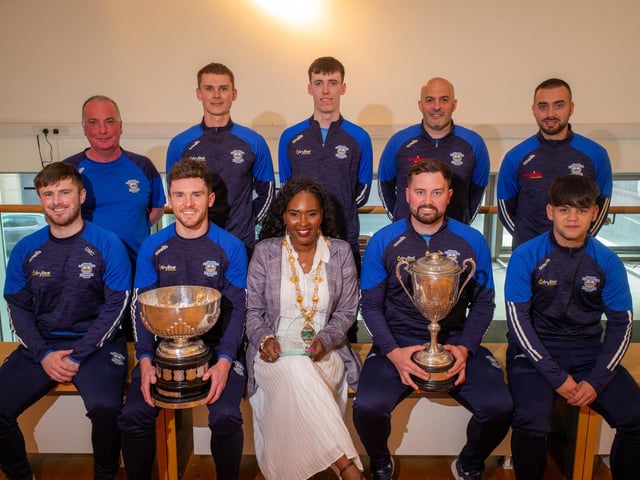 The Men's Senior Team holding their Intermediate League winner’s trophy, and the O'Gorman Cup, pictured with the Mayor Lilian Barr and club chair Seamus McElroy.