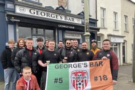 Derry City fans proudly display their flag outside George's Bar before heading on the bus to Dublin.