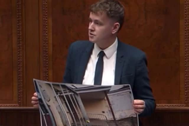 Pádraig Delargy holding up photographs of dilapidated schools in Derry in Stormont on Tuesday as he called for greater investment in the schools estate in the city.