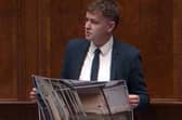 Pádraig Delargy holding up photographs of dilapidated schools in Derry in Stormont on Tuesday as he called for greater investment in the schools estate in the city.