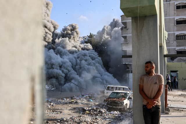 A man takes cover behind a column as an explosion propagates smoke and dust during an Israeli strike which reportedly targeted a school in the Zeitoun district on the outskirts of Gaza City, on September 1, 2024, amid the ongoing conflict between Israel and the Palestinian Hamas group. (Photo by Omar AL-QATTAA / AFP) (Photo by OMAR AL-QATTAA/AFP via Getty Images)