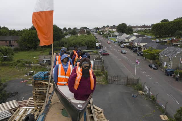 MOYGASHEL, JULY 10: A model of a small boat with several figures depicting migrants inside can be seen on top of a loyalist bonfire on July 10, 2025 in Moygashel. Loyalists have constructed a bonfire effigy depicting a boat full of migrants with mannequins wearing lifejackets and placards reading "Stop the boats," and "Veterans before refugees." The effigy was burned atop a pyre of pallets on Thursday night. Moygashel Bonfire Committee has said that the bonfire "topper" should not be seen as "racist, threatening or offensive" and it was "expressing our disgust at the ongoing crisis that is illegal immigration". (Photo by Charles McQuillan/Getty Images)