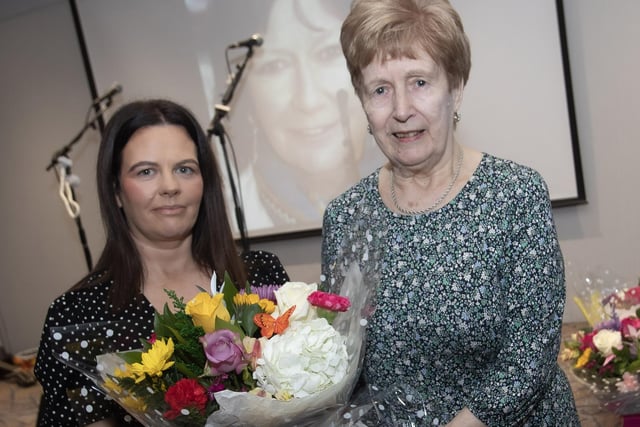 Ann Gallagher receiving a bouquet of flowers on behalf of her late sister Maureen, who's contribution as a loyal and good neighbour to many within her community.