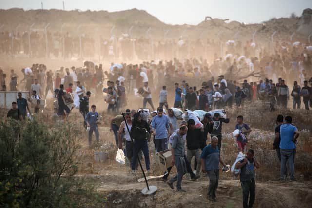 People carry relief supplies from the Gaza Humanitarian Foundation (GHF), a private US-backed aid group that has bypassed the longstanding UN-led system in the territory, as displaced Palestinians return from an aid distribution centre in the central Gaza Strip on June 8, 2025. The UN and major aid organisations have refused to cooperate with the GHF, citing concerns that it was designed to cater to Israeli military objectives. (Photo by Eyad BABA / AFP) (Photo by EYAD BABA/AFP via Getty Images)
